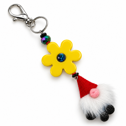 Yellow flower purse charm with a blue crystal center, iridescent bead, red-hatted gnome with a white beard, and silver-tone clasp and keyring.


